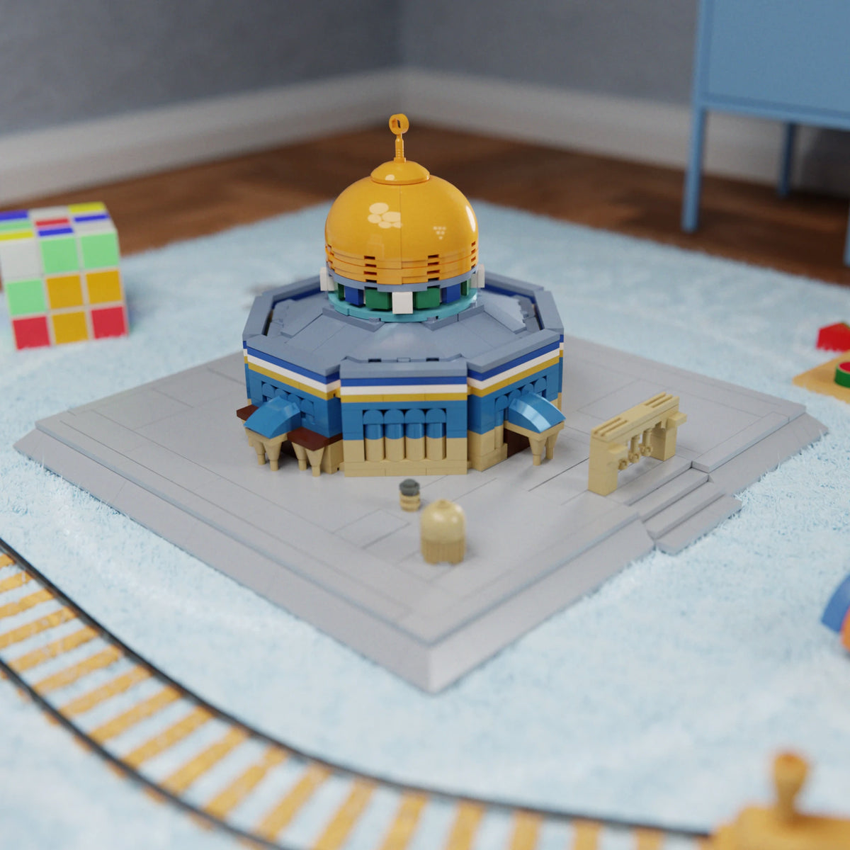 Modello islamico del Tempio della Rocca di al-Aqsa compatibile con LEGO di ALIFAAT su un tappetino da gioco blu, con un cubo di Rubik e binari di treno in legno